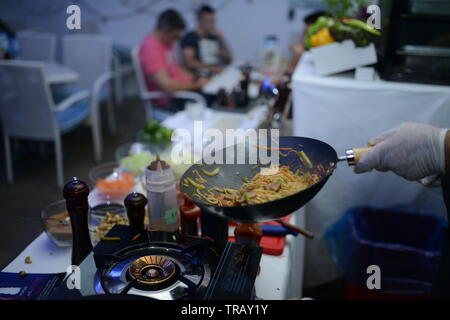 Lo chef cucina il cibo nel ristorante Foto Stock