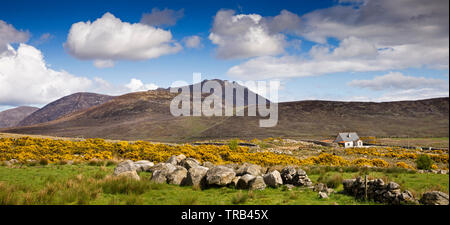 Irlanda del Nord, Co Down, Alta Mournes, cottage isolato nel paesaggio roccioso in acqua gialla Valley, al di sotto del picco di Slieve Binnan, panoramica Foto Stock