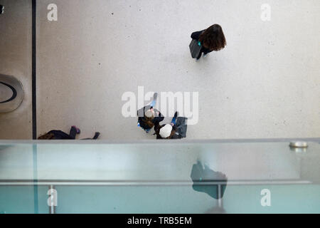 Scatto dall'alto di una folla di gente che passando da sotto dentro la stazione centrale di Amsterdam Foto Stock