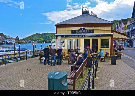 Un bel dipinto di giallo edificio di legno occupata dalla piattaforma 1 Champagne Bar & Restaurant. Le splendide viste sul fiume Dart.gente seduta al di fuori di . Foto Stock