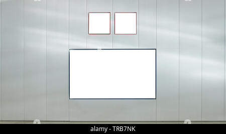 Blank cartelloni con cartelli di indicazione sul muro grigio Foto Stock