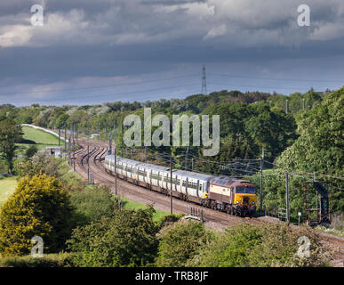 Le operazioni ferroviarie gruppo classe 57 locomotiva diesel sulla linea principale della costa occidentale tira fuori classe leasing 365 elettrico unità multiple per lo storage Foto Stock