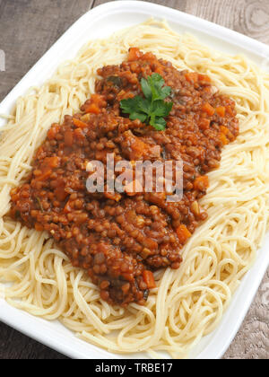 Saporiti spaghetti organico vegetariano con il ragù alla bolognese in un rustico tavolo da cucina Foto Stock
