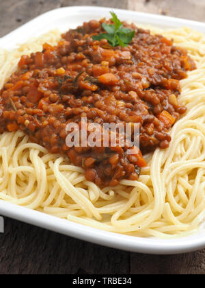 Saporiti spaghetti organico vegetariano con il ragù alla bolognese in un rustico tavolo da cucina Foto Stock