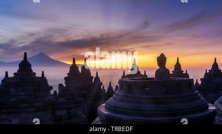 Statua di Buddha a sunrise, Il Tempio Borobudur complessa, il Borobudur, Yogyakarta, Java, Indonesia Foto Stock