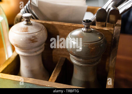 In legno eleganti sale e pepe mulini in una cassa di legno su una tavola di ristorante Foto Stock