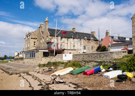 Barche capovolta sulla riva del mare da Findhorn casa costruita nel 1775 home di Findhorn Royal Yacht Club affacciato sulla Baia di Findhorn. Findhorn, murene, Scozia, Regno Unito, Foto Stock