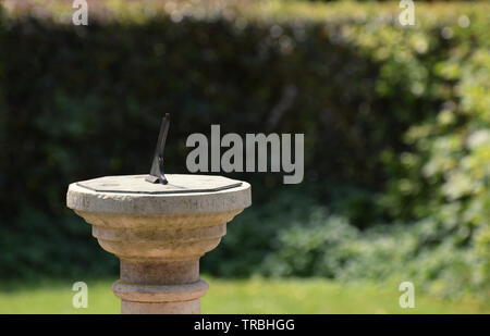 Tradizionale di pietra sun dial in un giardino inglese Foto Stock