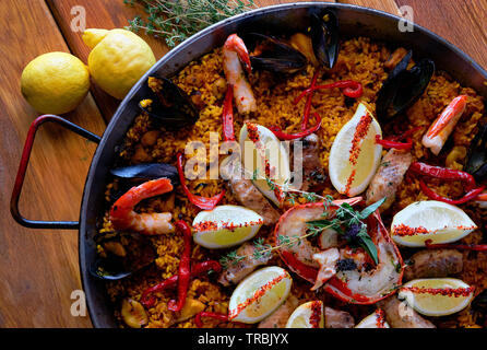 Deliziosi frutti di mare spagnolo paella, vista dall'alto. In cotto con storione filetto di halibut, gamberetti sgusciati, Calamari Cozze astice decorate con limone Foto Stock