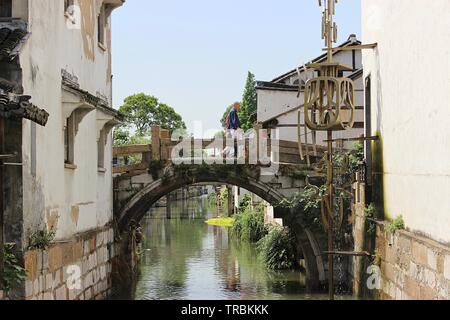 Un antico ponte con due uomini a piedi attraverso Foto Stock