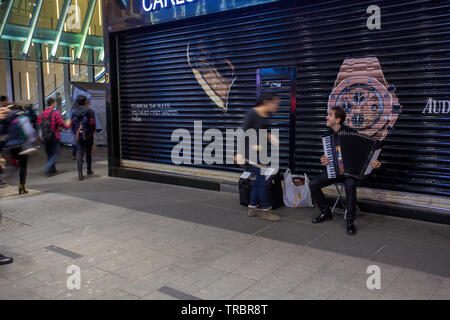 01/25/2015 Hong Kong l'uomo sta suonando la fisarmonica e la gente sta andando a Hong Kong dal proprio modo . Formicaio umano Foto Stock