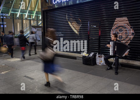 01/25/2015 Hong Kong l'uomo sta suonando la fisarmonica e la gente sta andando a Hong Kong dal proprio modo . Formicaio umano Foto Stock