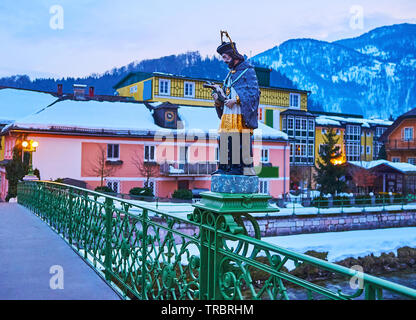 La passeggiata serale lungo la storica Kaiserin Elizabeth Bridge con vista sulla statua di Johannes Nepomuk, vecchie case a schiera e le montagne nevose sul backgro Foto Stock