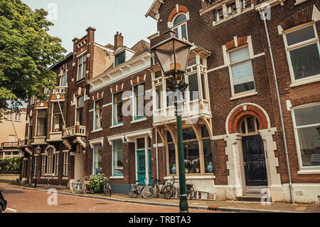 Facciata di eleganti edifici in mattoni e biciclette su strada a Dordrecht. Città con importante e storico porto nei Paesi Bassi. Foto Stock