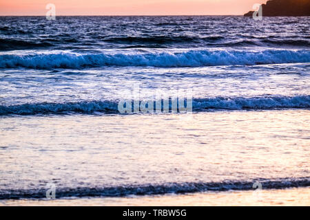 Onde che si infrangono sulla spiaggia al tramonto, il Whitesands Bay, St Davids, Pembrokeshire National Park, Wales, Regno Unito Foto Stock