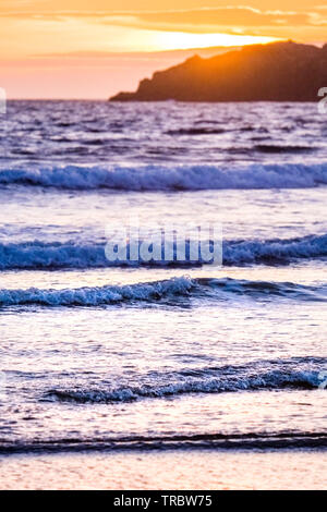 Onde che si infrangono sulla spiaggia al tramonto, il Whitesands Bay, St Davids, Pembrokeshire National Park, Wales, Regno Unito Foto Stock