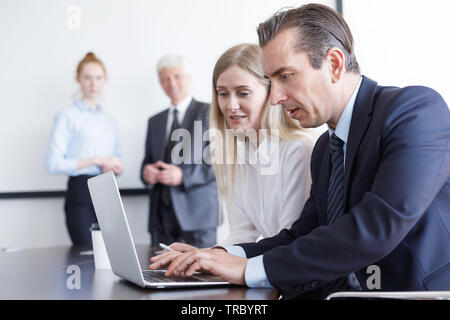 La gente di affari a lavorare con il computer portatile insieme in ufficio Foto Stock