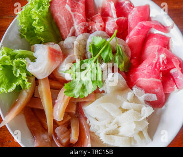 Set di shabu crudo fresco di carne di manzo e di maiale calamari gamberetti pesce pesce e verdure sul recipiente per la cottura di grigliate barbecue o sode shabu
