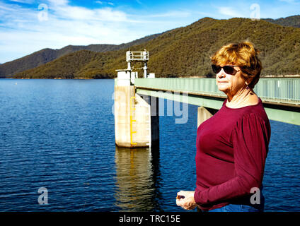 Turista femminile che guarda fuori sopra la diga di Tumut, parte del programma idroelettrico delle montagne di Snowy vicino a Talbingo, nuovo Galles del Sud, in Australia Foto Stock