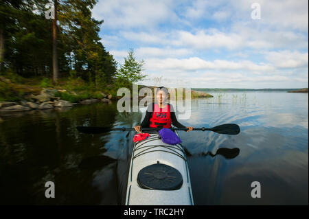 Fotografo Outdoor Zizza Gordon paddling in un kayak nel lago Vansjø, Østfold, Norvegia. Il lago Vansjø è il lago più grande in Østfold. Vansjø e i suoi dintorni di laghi e fiumi sono una parte dell'acqua sistema chiamato Morsavassdraget. Giugno, 2010. Foto Stock