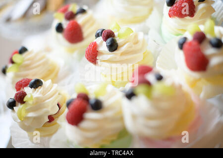 Deliziosa crema pasticcera e frutti di bosco tortini, assortimento di dolci e torte display a una caramella a buffet, gustose varietà di dessert adatta per una festa di compleanno Foto Stock