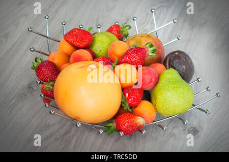 La frutta in un vaso su sfondo bianco Foto Stock