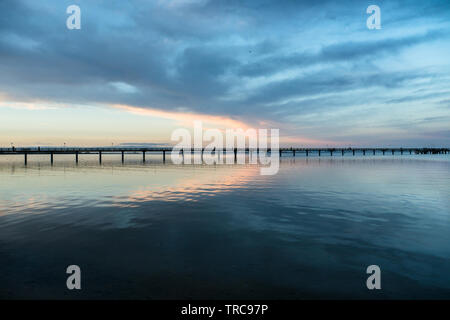 Silhouette di un molo vicino a Wismar presso il Mar Baltico, Meclenburgo-Pomerania Occidentale, Germania, sparato contro il cielo della sera che si riflette nell'acqua Foto Stock