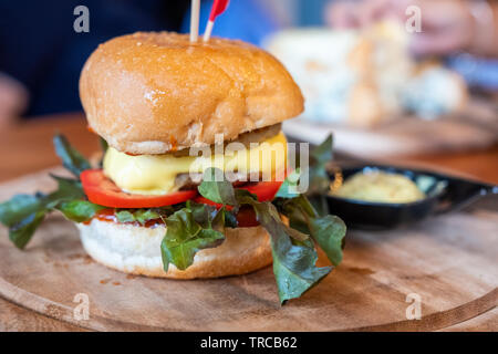 Hamburger fatti in casa con carne di maiale e il formaggio sul vassoio in legno Foto Stock