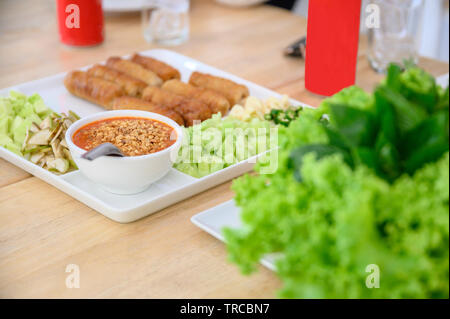 Nam-Neaung del cibo vietnamita con rotolo di maiale, verdure e salsa su un tavolo di legno Foto Stock