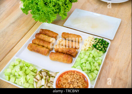 Nam-Neaung del cibo vietnamita con rotolo di maiale, verdure e salsa su un tavolo di legno Foto Stock