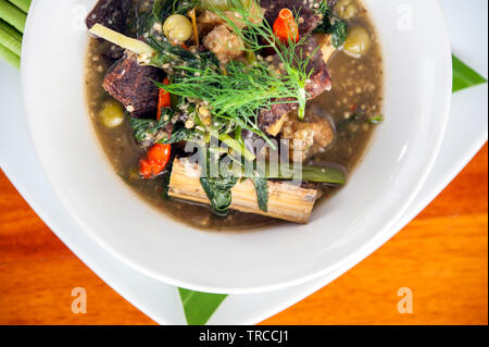 O Lam, uno spezzatino reso dal materiale osseo, peperoncino, citronella e carne affumicata, pestate di melanzane e addensato con riso appiccicoso, Luang Prabang, Laos. Foto Stock