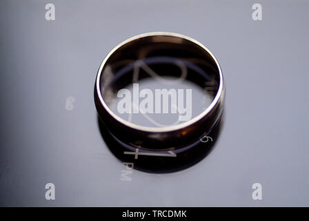 Il impegnato un anello di fidanzamento si siede in cima a un cellulare di visualizzazione di data e ora. Foto Stock