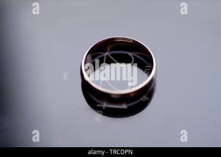 Il impegnato un anello di fidanzamento si siede in cima a un cellulare di visualizzazione di data e ora. Foto Stock