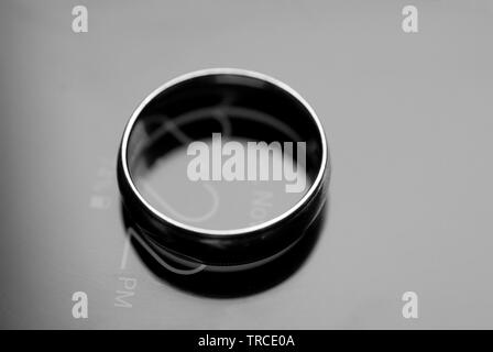 Il impegnato un anello di fidanzamento si siede in cima a un cellulare di visualizzazione di data e ora. Foto Stock