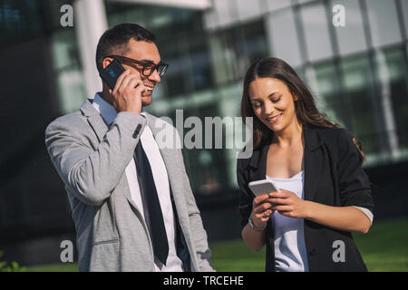 Colleghi di lavoro sono comunicante con l'esterno dell'edificio dell'azienda. Foto Stock