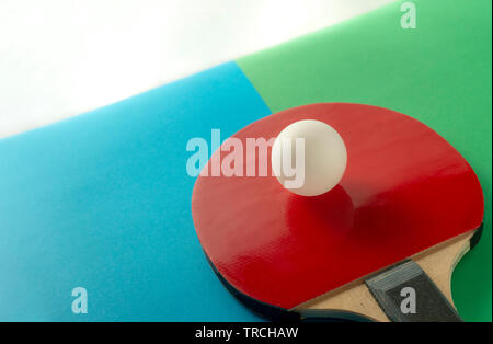 Tennis da tavolo o ping pong racchette e palle su blu e tavolo verde, il fuoco selettivo Foto Stock