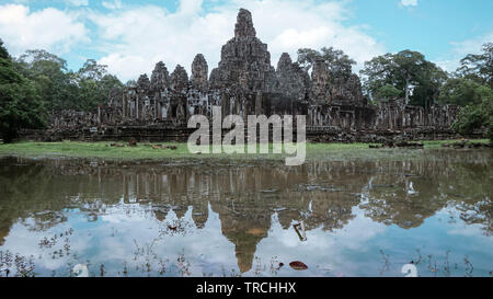 Ampia vista del tempio Bayon con il bellissimo tempio di pietra di torri e la loro riflessione in piscina di acqua (Angkor Wat, Siem Reap, Cambogia). Foto Stock