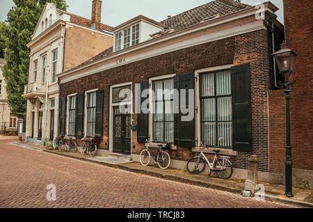 Facciata di eleganti edifici in mattoni e biciclette su strada a Dordrecht. Città con importante e storico porto nei Paesi Bassi. Foto Stock