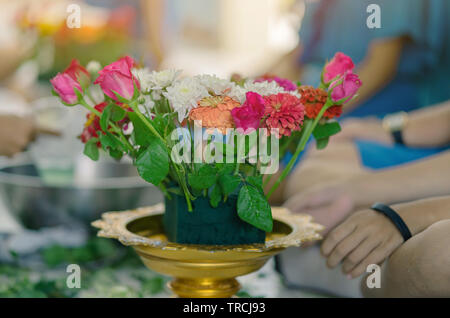 Gli studenti si aiutano a vicenda per creare un vassoio di fiori con il piedistallo per gli Insegnanti" Giorno Foto Stock