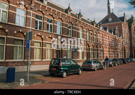 Strada con case in mattoni e ombra di alberi al tramonto in s-Hertogenbosch. Graziosa città storica con la vibrante vita culturale nei Paesi Bassi. Foto Stock