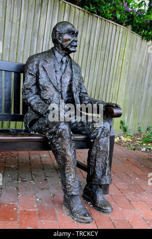 Una statua di bronzo di Rudyard Kipling si siede nella strada alta della East Sussex villaggio di Burwash. Kipling vivevano nel villaggio per 34 anni. Foto Stock