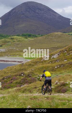 Mountain Biker da Loch Slapin e Beinn na Caillich, Red Cuillin Hills sotto un nuvoloso cielo di autunno. Vedere di Skye, Scotland, Regno Unito. Foto Stock