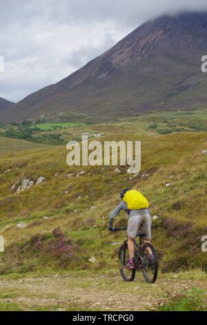 Mountain Biker da Loch Slapin e Beinn na Caillich, Red Cuillin Hills sotto un nuvoloso cielo di autunno. Vedere di Skye, Scotland, Regno Unito. Foto Stock