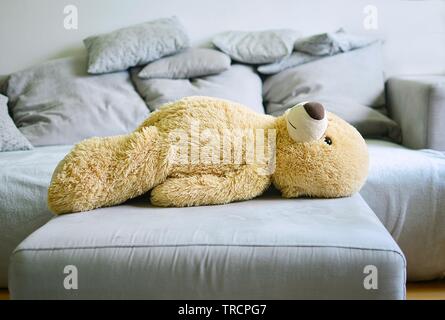 Il grande orso di peluche giace su un divano Foto Stock