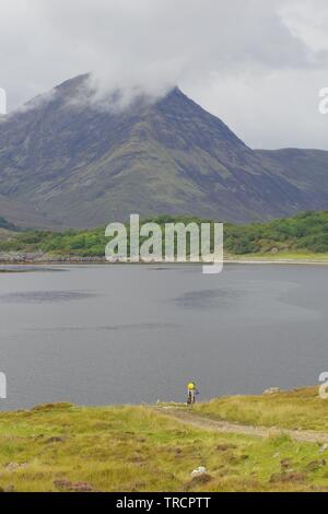 Mountain Biker da Loch Slapin e Beinn na Caillich, Red Cuillin Hills sotto un nuvoloso cielo di autunno. Vedere di Skye, Scotland, Regno Unito. Foto Stock