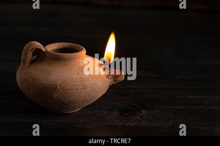 Accesa a mano lampada a petrolio dal Medio Oriente al buio su un tavolo Foto Stock