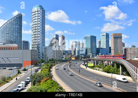 East End di Londra alto edificio di appartamenti soddisfano Canary Wharf financial district banking grattacielo skyline con la circolazione su strada e il trasporto di DLR link England Regno Unito Foto Stock