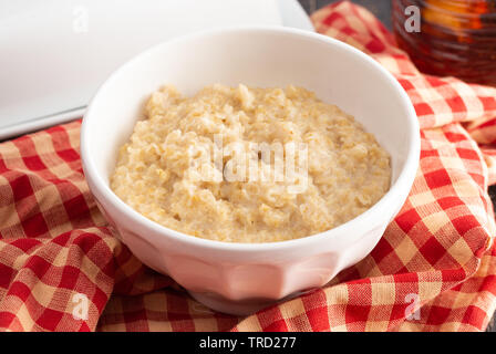 Plain Farina di avena su un tavolo di legno con rosso a scacchi Tovaglia Foto Stock