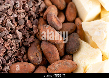 Un background di righe di cioccolato di naselli le fave di cacao e burro di cacao Foto Stock