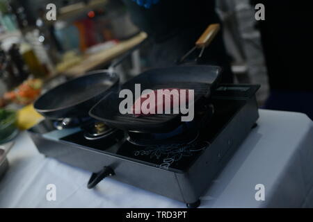 Lo chef arrosta carne al ristorante Foto Stock